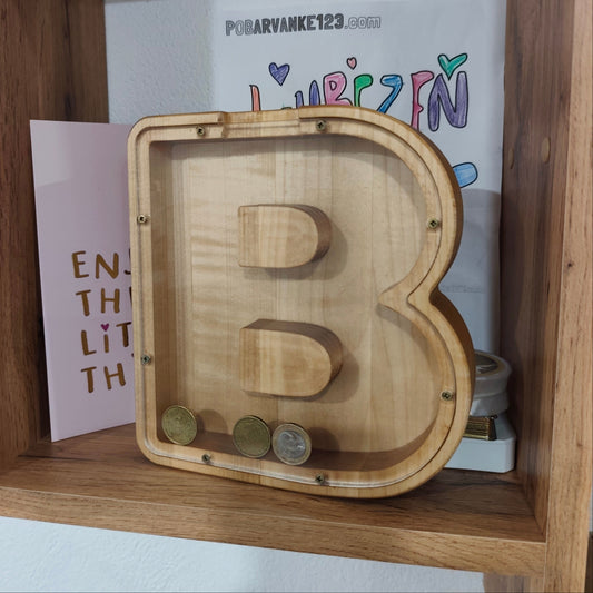 Lesen hranilnik v obliki črke, napolnjen s kovanci, kot dekoracija v otroški sobi
