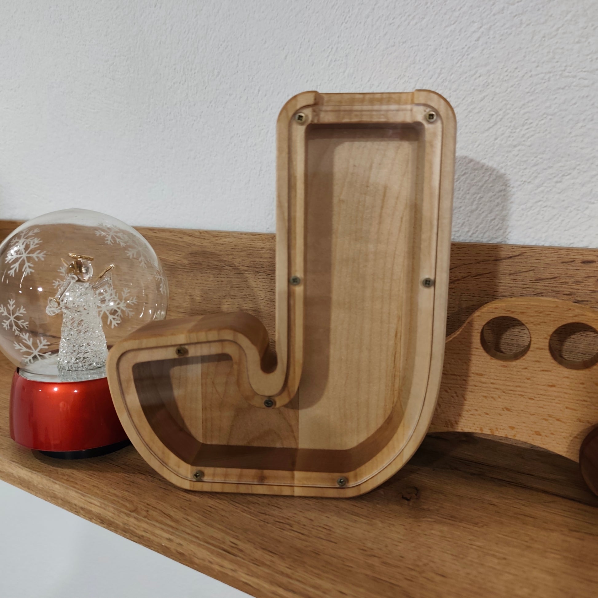 Lesen hranilnik v obliki črke kot naravna lesena dekoracija na polici